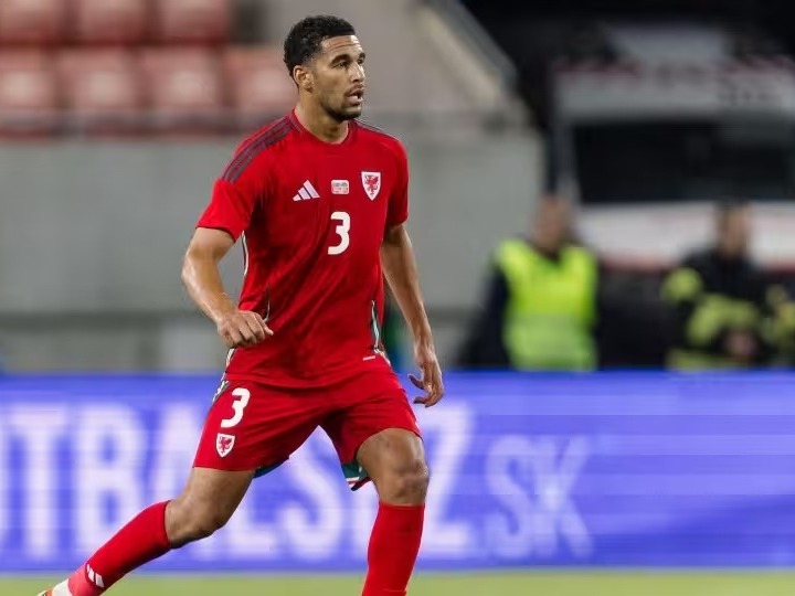 Ben Cabango in a red Wales shirt with the number 3, running during an away international