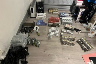 Hundreds of packets of counterfeit cigarettes and hand-rolling tobacco laid out in rows on a wooden floor after being seized in the Mansel Street raids