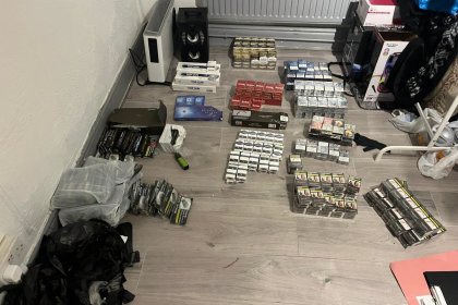 Hundreds of packets of counterfeit cigarettes and hand-rolling tobacco laid out in rows on a wooden floor after being seized in the Mansel Street raids