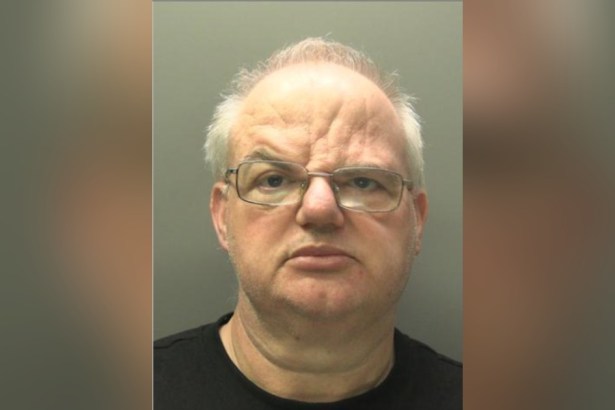 Custody image of Craig Henton, a bald man with glasses, against a grey background
