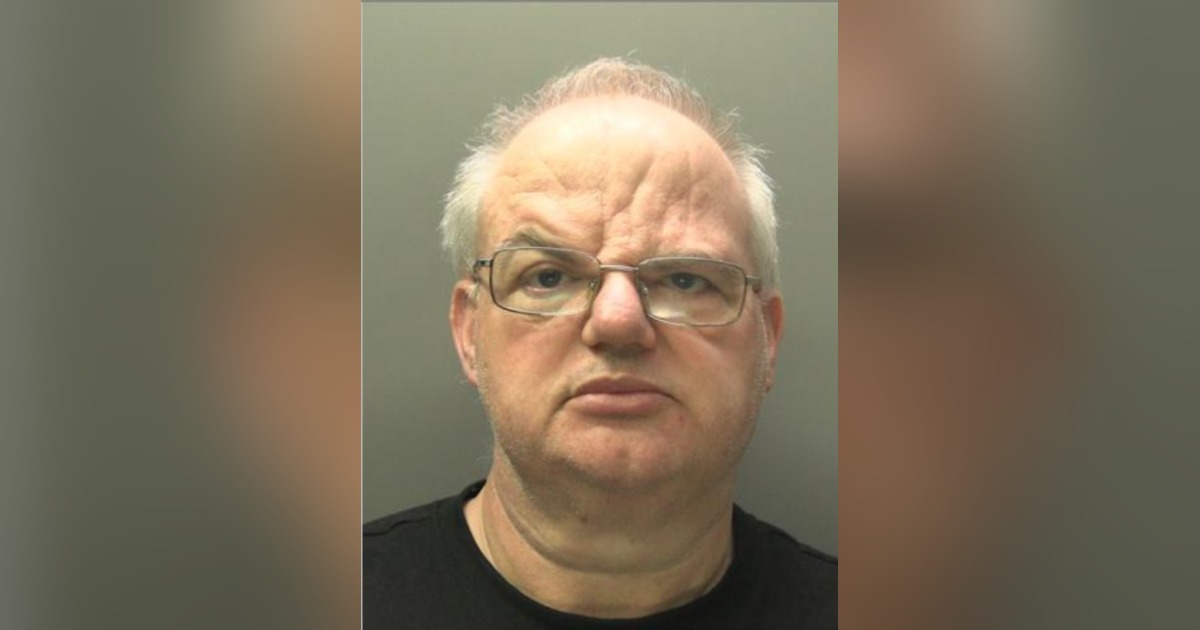 Custody image of Craig Henton, a bald man with glasses, against a grey background