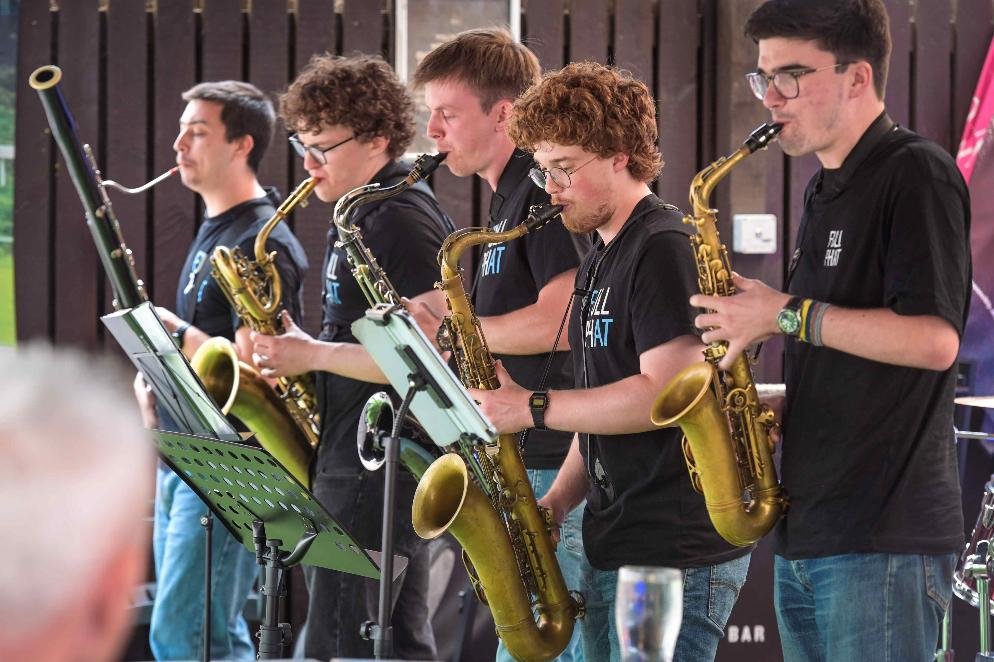 Five saxophonists from Full Phat performing in a line at Swansea International Jazz Festival