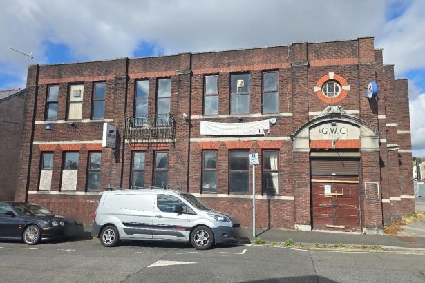Two-storey red-brick former working men's club on Brighton Road, Gorseinon, with G.W.C. carved above a shuttered doorway and windows boarded
