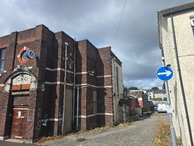 Side view of the red-brick Gorseinon Working Men's Club showing the arched entrance at the corner and a one-way road sign