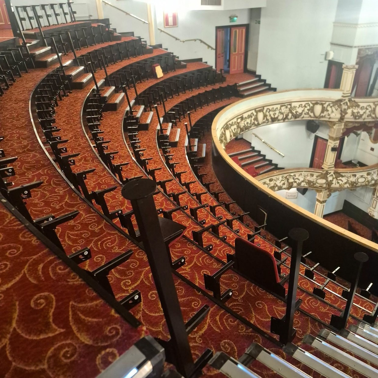 The Upper Circle at Swansea Grand Theatre mid-installation, with new seats in place and new handrails on the stepped aisles
