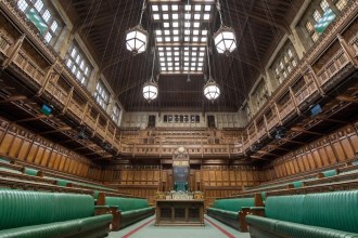 The empty green benches of the House of Commons chamber, looking towards the Speaker's chair