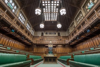 The empty green benches of the House of Commons chamber, looking towards the Speaker's chair