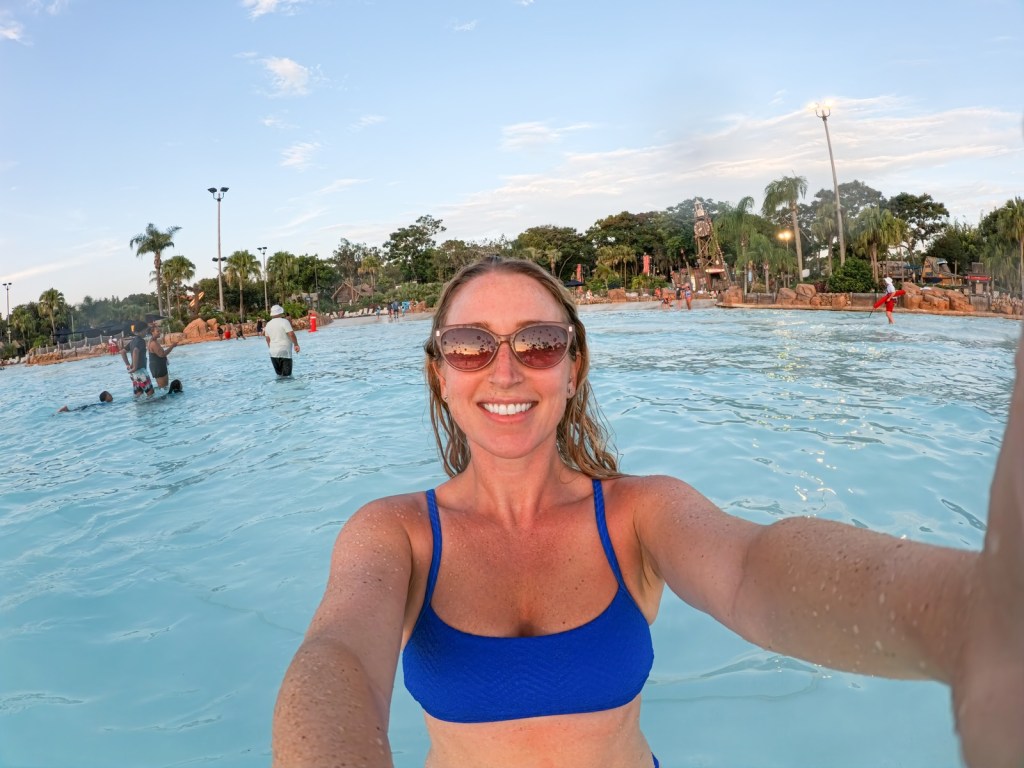 Joely McNamara smiling in a blue bikini standing in the shallows at a Florida water park