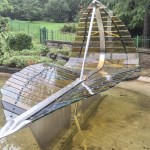 The steel and glass Leaf Boat sculpture standing in the refilled ornamental pond at Cwmdonkin Park, Swansea