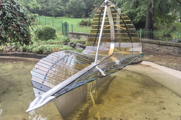 The steel and glass Leaf Boat sculpture standing in the refilled ornamental pond at Cwmdonkin Park, Swansea