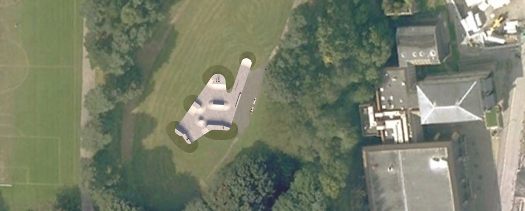 Aerial photograph of Maesteg Welfare Park with the outline of the proposed concrete skatepark overlaid on the grass beside the existing tarmac path, next to the playing fields