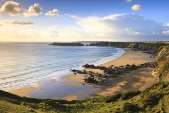 Marloes Sands beach at low tide from the cliff path, with Gateholm and Skokholm in the distance