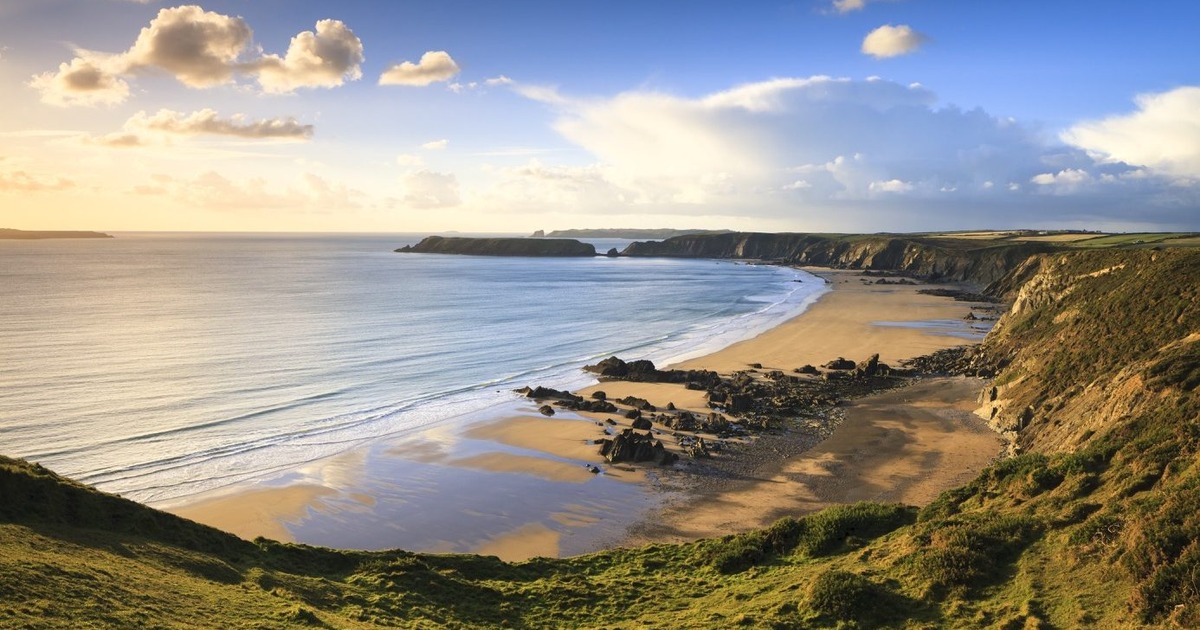 Marloes Sands beach at low tide from the cliff path, with Gateholm and Skokholm in the distance