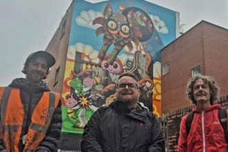 Hasan Kamil, Cllr Elliott King and Gareth Lye standing in front of the new Park Street mural in Swansea