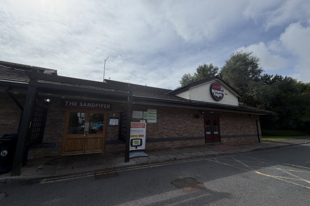 The Sandpiper Brewers Fayre at Sandy Water Park in Llanelli with its entrance doors closed and the menu display case beside them empty