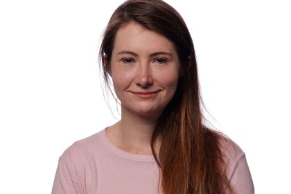 Official Senedd portrait of Sarah Cooper-Lesadd MS, smiling, with long auburn hair, in a pale pink top against a white background