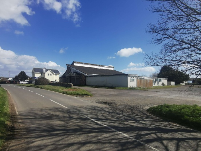 The closed former Countryman pub in Scurlage, a low rendered building with a pitched roof beside an empty car park and the B4247