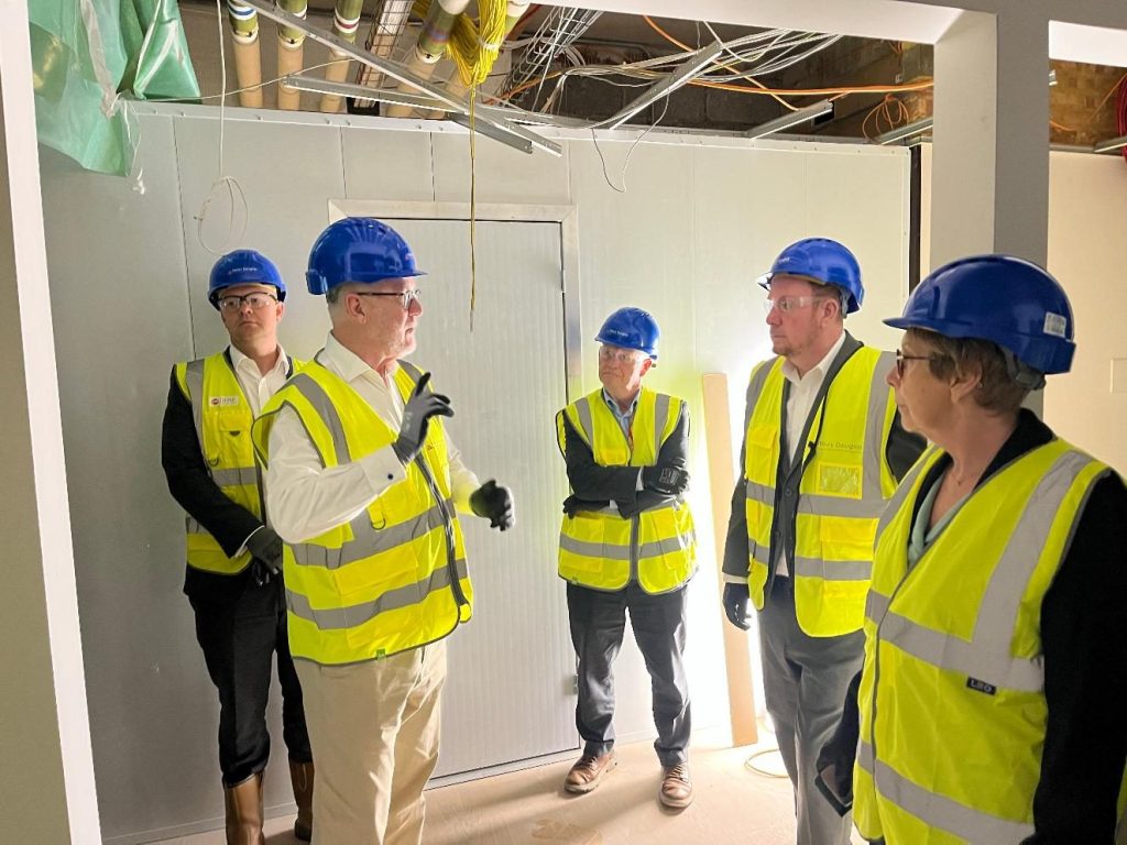 Swansea Council leader Rob Stewart and chief executive Martin Nicholls with health board and project staff in hard hats at the PET-CT centre construction site at Singleton Hospital
