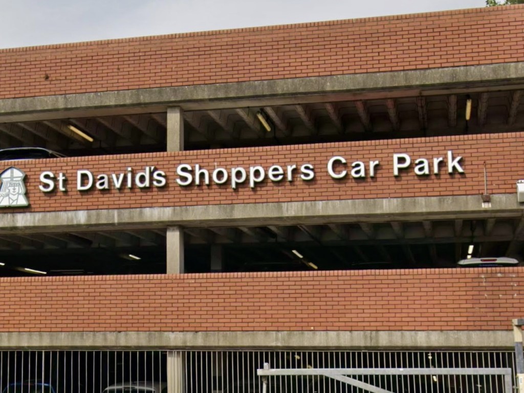 Close-up of the white St David's Shoppers Car Park lettering and bishop emblem on the red-brick multi-storey