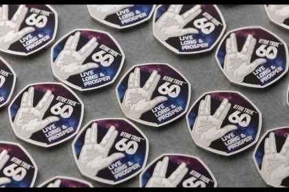 Two Star Trek 60th anniversary 50p coins, one with the Vulcan salute and Live Long & Prosper, one with four starships against a colour nebula
