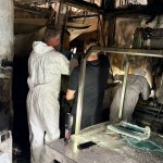 People in white protective suits examining the burnt-out kitchen at Verdi's in Mumbles, with scorched walls, ceiling and steel counters
