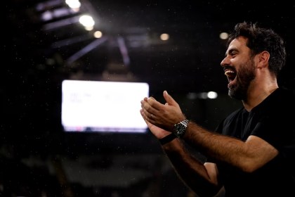 Swansea City head coach Vitor Matos applauding and laughing under the floodlights at the Swansea.com Stadium