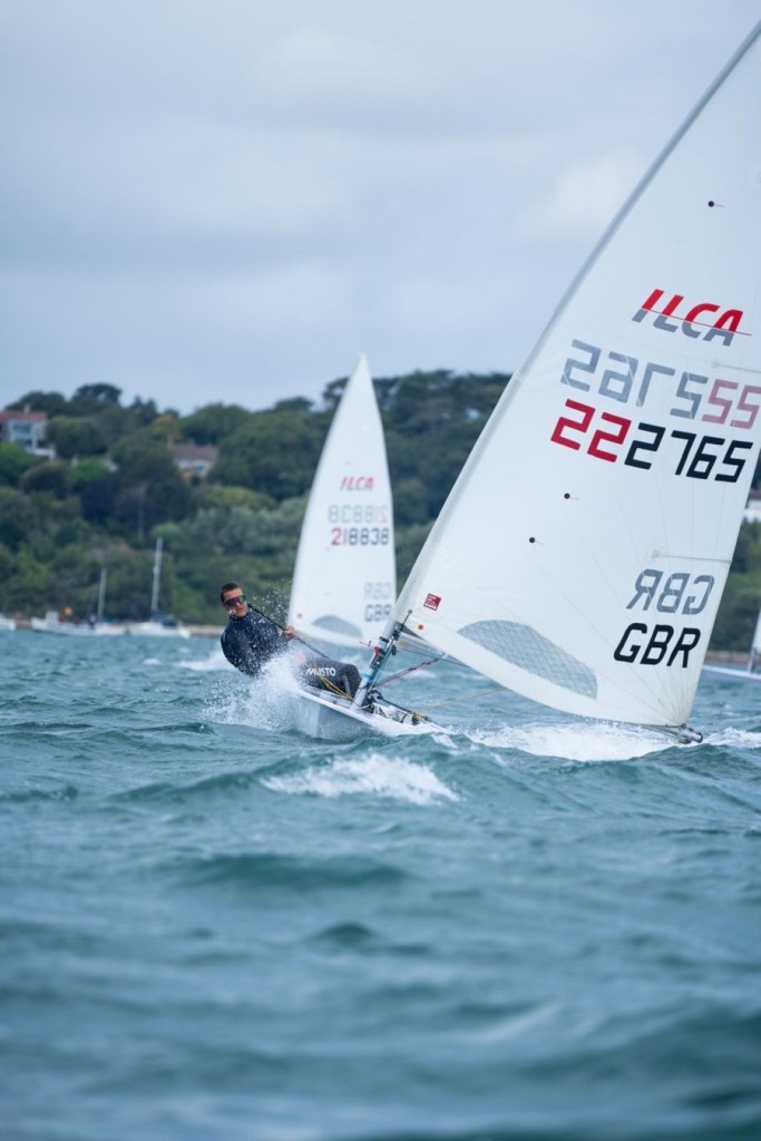 Wilf Tovey hiked out over the side of his ILCA dinghy, sail number 222765 and GBR on the sail, racing in choppy water
