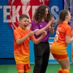 Ysgol Tyle'r Ynn pupils in orange Tekkers kit celebrating alongside presenter Huw Owen on the show's pitch