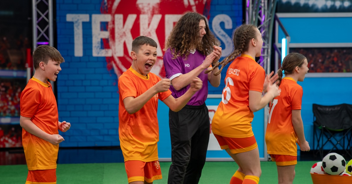 Ysgol Tyle'r Ynn pupils in orange Tekkers kit celebrating alongside presenter Huw Owen on the show's pitch