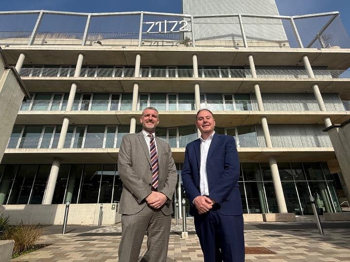 IWG's Mark Potton and council leader Rob Stewart in suits outside the glass and concrete 71/72 Kingsway office building, with the 71/72 sign on its roof