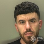 South Wales Police custody photograph of Abdullah Saed, a man with short dark curly hair and a beard