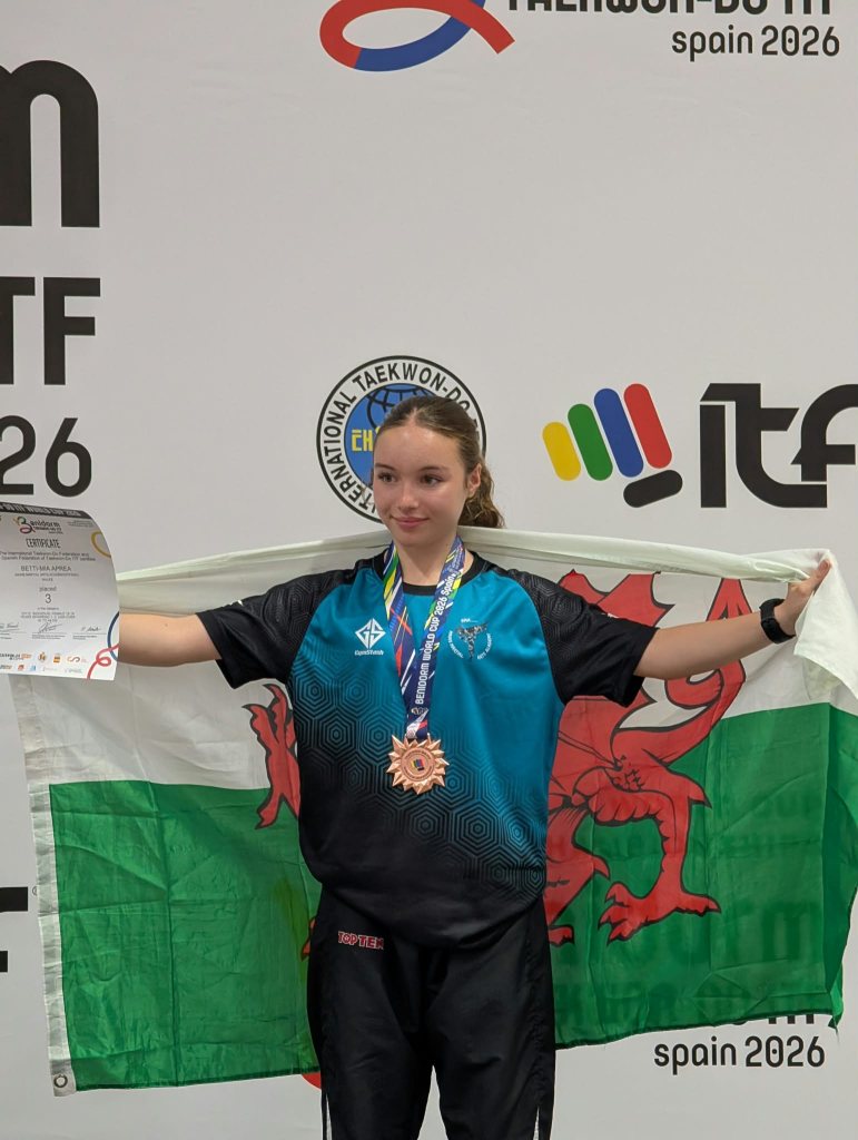 Betti-Mia Aprea holds a Welsh flag and her certificate, with a bronze medal round her neck, at the World Cup in Benidorm
