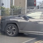 A grey Hyundai SUV with its front against a damaged brick wall and railings on Coity Road, Bridgend