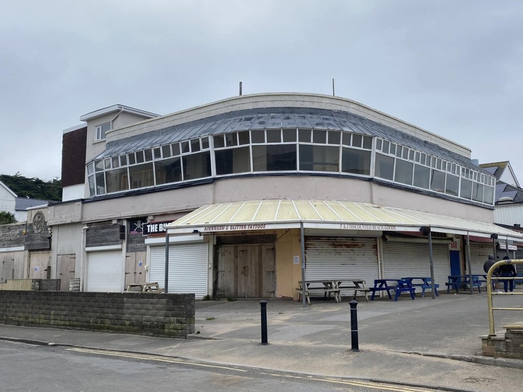 The Buccaneer on Porthcawl seafront with its shutters down, showing its curved frontage and long run of upper-floor windows