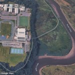 Aerial view of Carmarthen Leisure Centre in Johnstown with the grassed field beside its tennis courts, Llansteffan Road to the left and the River Towy to the right