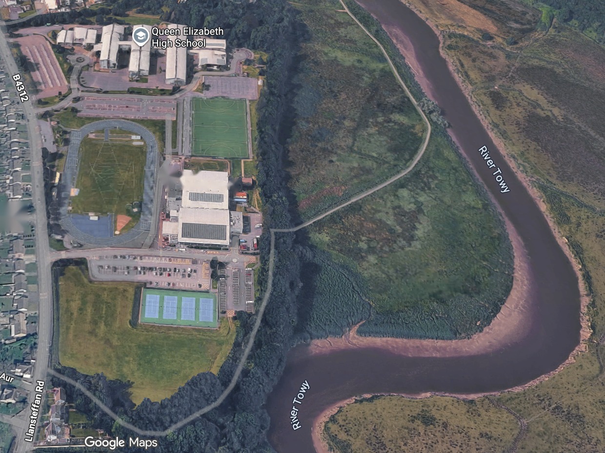 Aerial view of Carmarthen Leisure Centre in Johnstown with the grassed field beside its tennis courts, Llansteffan Road to the left and the River Towy to the right
