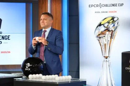 The EPCR Challenge Cup trophy on display beside a man drawing a ball at the Challenge Cup pool draw