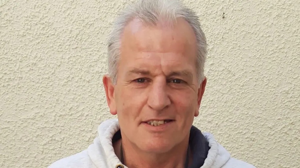 Head-and-shoulders photo of Clifford Foster, a grey-haired man in a white hooded top, against a cream wall