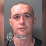 South Wales Police custody photograph of Daniel Green, a man with a shaved head and a neck tattoo