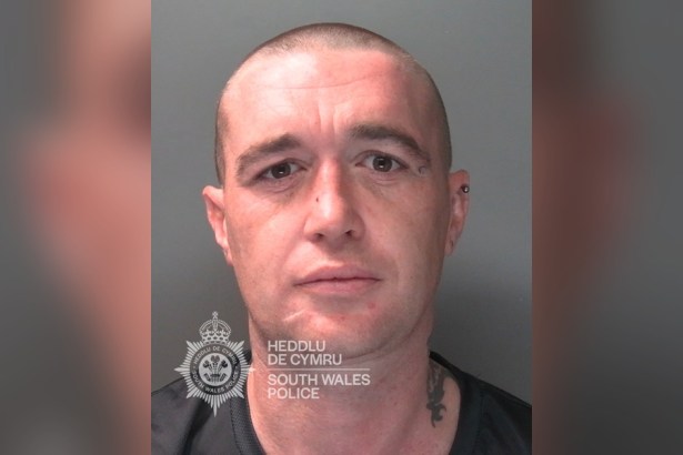 South Wales Police custody photograph of Daniel Green, a man with a shaved head and a neck tattoo