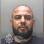 South Wales Police custody photograph of David Novac, a man with a shaved head and a dark beard