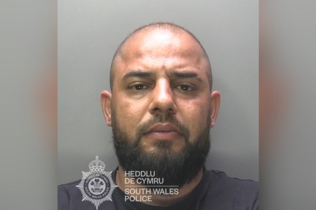 South Wales Police custody photograph of David Novac, a man with a shaved head and a dark beard