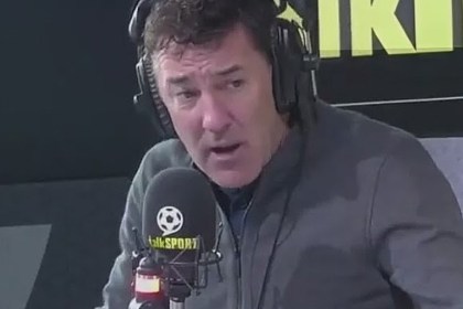 Former Wales striker Dean Saunders wearing headphones and speaking into a talkSPORT microphone in the radio studio