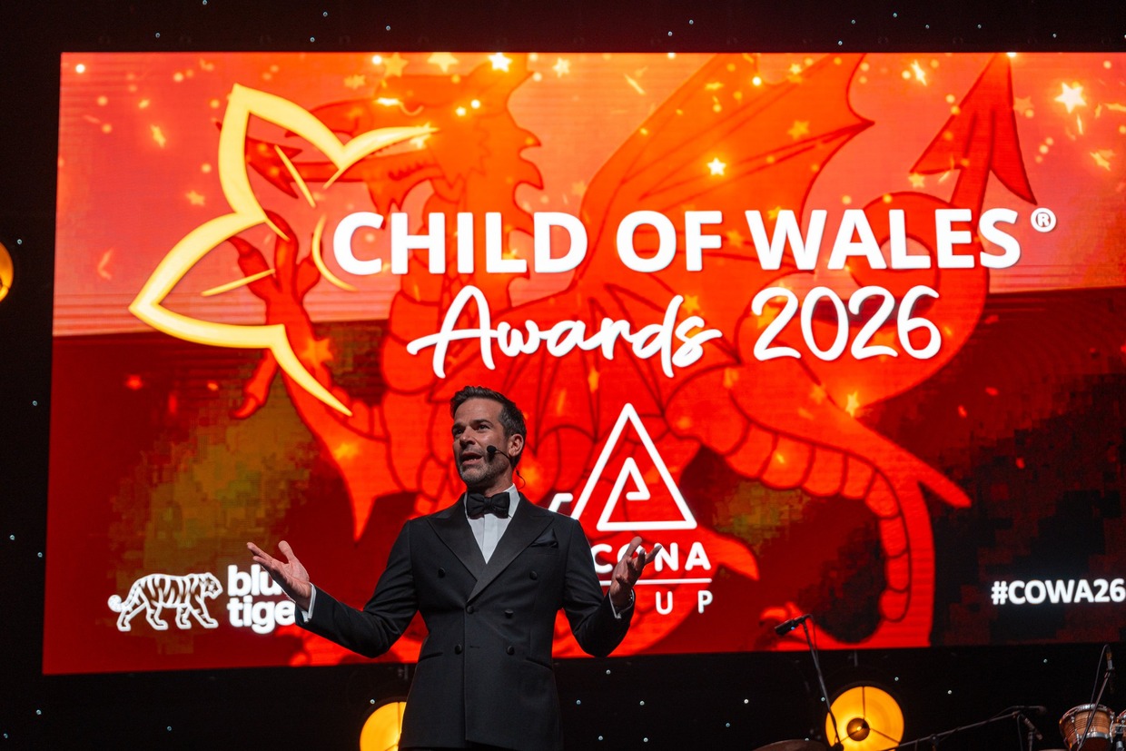 Gethin Jones holding a microphone on stage at the Child of Wales Awards 2026 in Swansea Building Society Arena