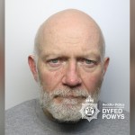 Dyfed-Powys Police custody photograph of James McKenna, a bald man with a white beard