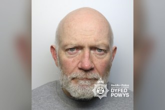 Dyfed-Powys Police custody photograph of James McKenna, a bald man with a white beard