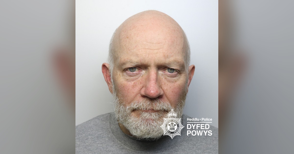 Dyfed-Powys Police custody photograph of James McKenna, a bald man with a white beard