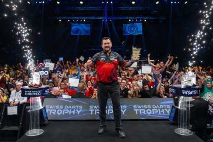 Jonny Clayton gives a thumbs up as he holds the Swiss Darts Trophy on stage in Basel in front of the crowd