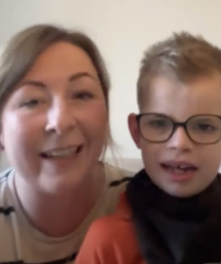Lana Dakin smiling next to her son Jac, who wears glasses and a dark top, in a video call