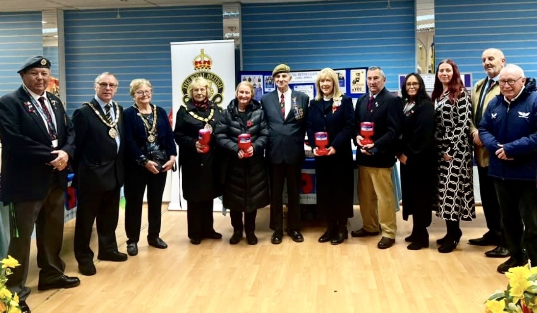 Guests at the Llanelli Poppy Appeal launch holding Royal British Legion collection tins